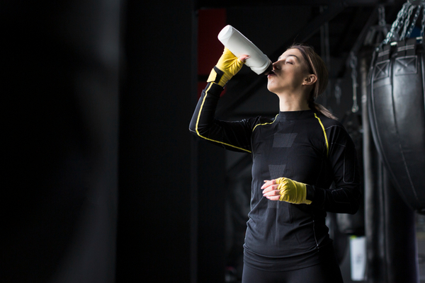 Sport-female-boxer-drinking-water-from-flask