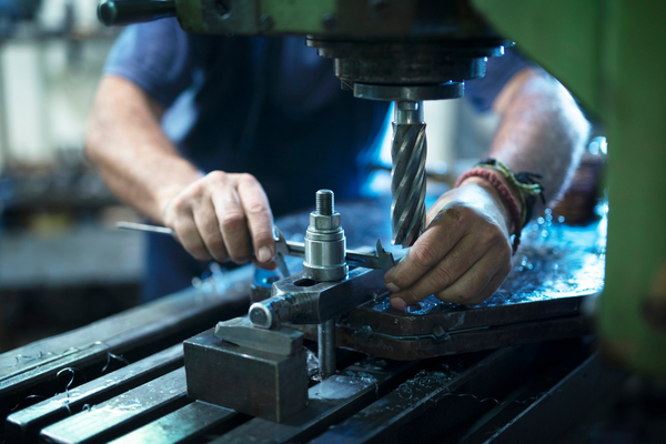 Worker-industrial-machine-in-metal-workshop